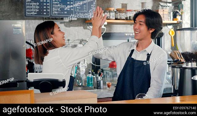 Young beautiful woman and handsome man barista wearing aprons owners cafe working win success order today at the counter of coffee shop