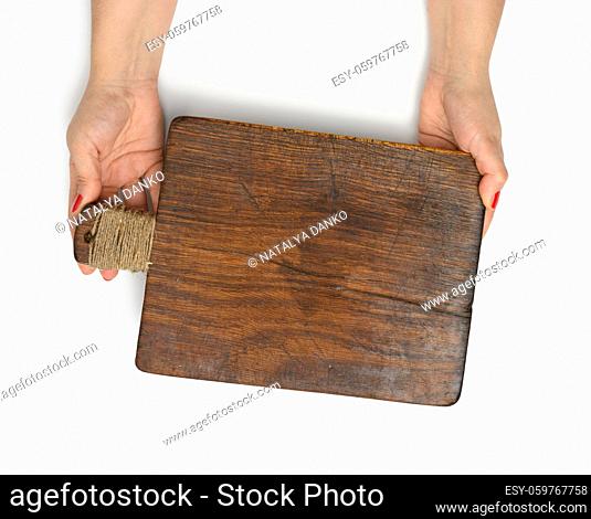 female hands hold empty rectangular brown wooden chopping board isolated on white background