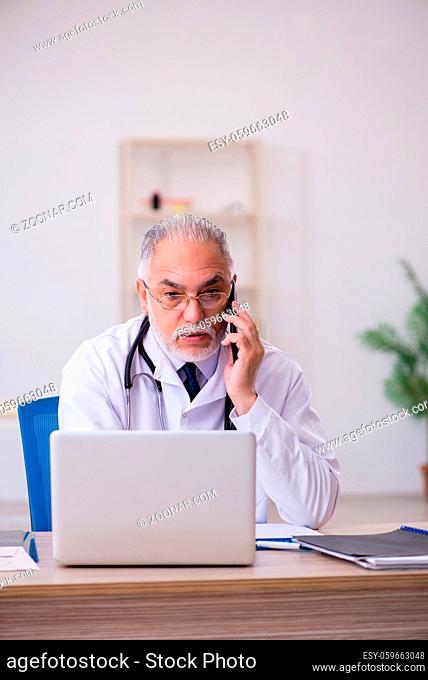 Aged male doctor in telemedicine concept