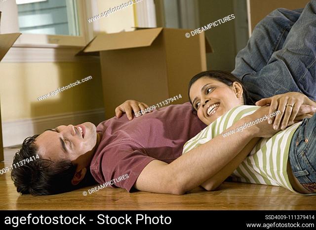Hispanic couple on floor next to moving boxes
