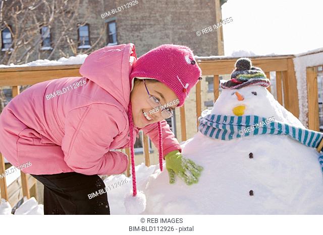 Hispanic girl making snowman
