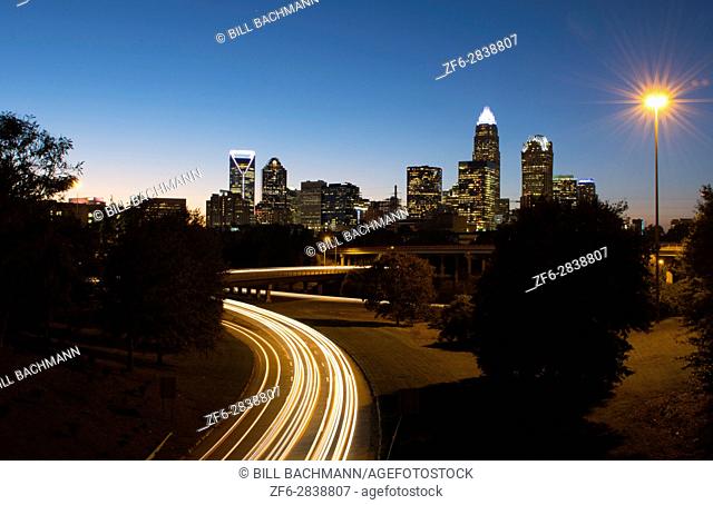 Charlotte North Carolina skyline at night with traffic blurs and twilight