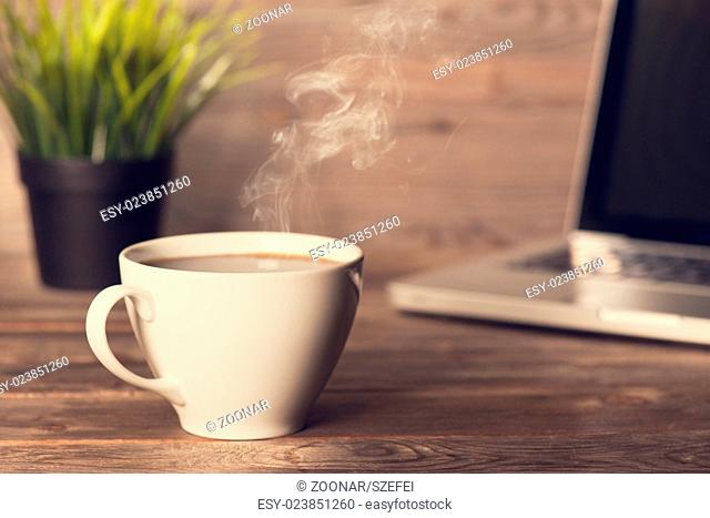 Hot coffee on wooden office desk