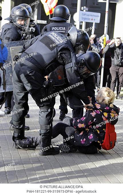 21 December 2018, Spain, Barcelona: Policemen detain a woman during a demonstration in support of Catalonia's independence