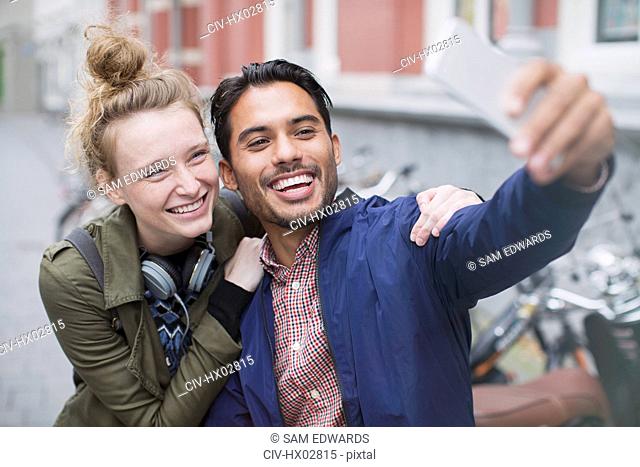 Smiling young couple taking selfie with camera phone