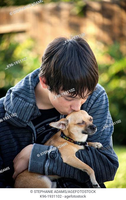 young man caring for small Chihuahua