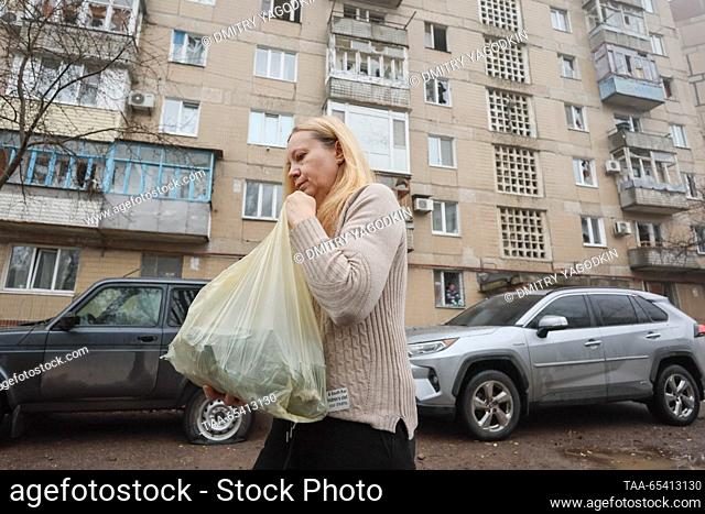 RUSSIA, DONETSK - DECEMBER 2, 2023: A woman walks past an apartment block damaged in a shelling of the Kirovsky neighbourhood by the Ukrainian Armed Forces