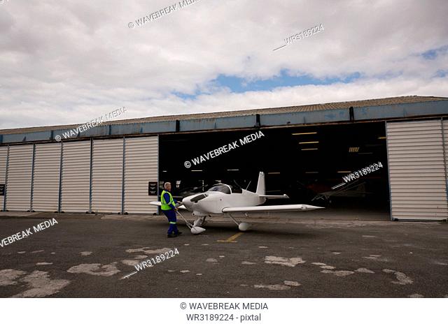 Crew member taking out aircraft from hangar