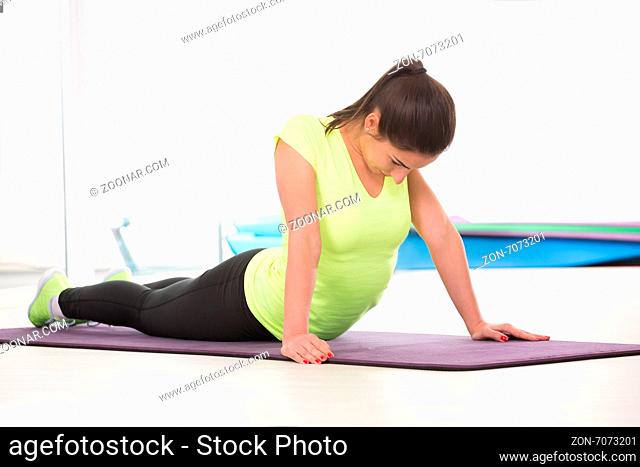 She like to rest on floor while stretching in sport gym