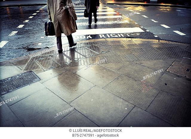 Unrecognizable businessmen with portfolios on pedestrian crossing, London, England