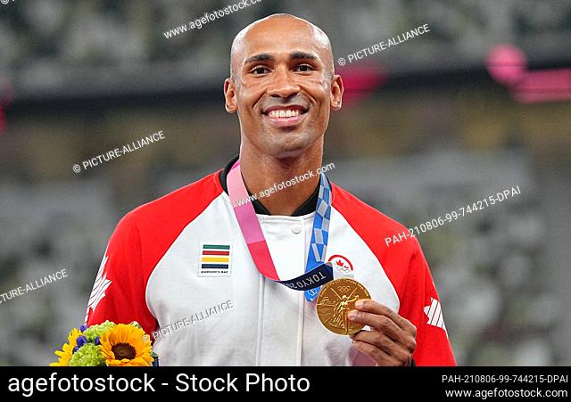 06 August 2021, Japan, Tokio: Athletics: Olympics, decathlon, men, at the Olympic Stadium. Damian Warner from Canada shows his gold medal at the award ceremony