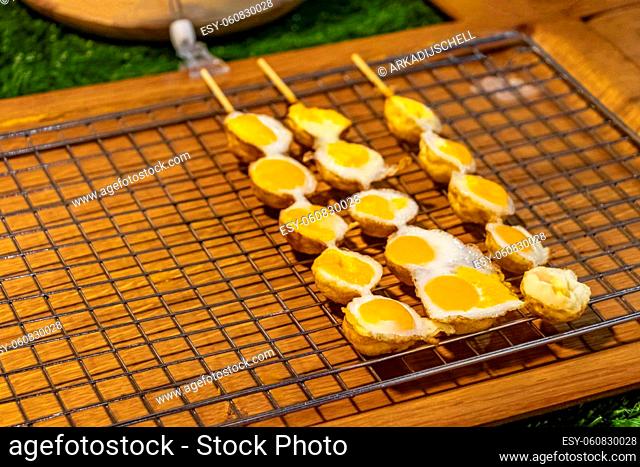 Quail eggs on a stick Thai night market street food in Huai Khwang Bangkok Thailand