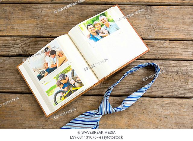 High angle view of photographs in book by necktie