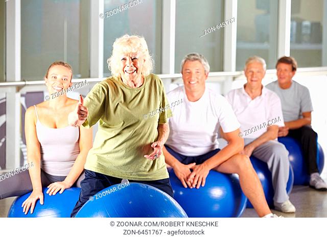 Alte lächelnde Frau im Fitnesscenter hält ihren Daumen hoch