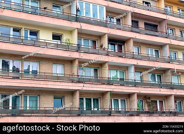 Facade of aged apartment building with houses and balcony