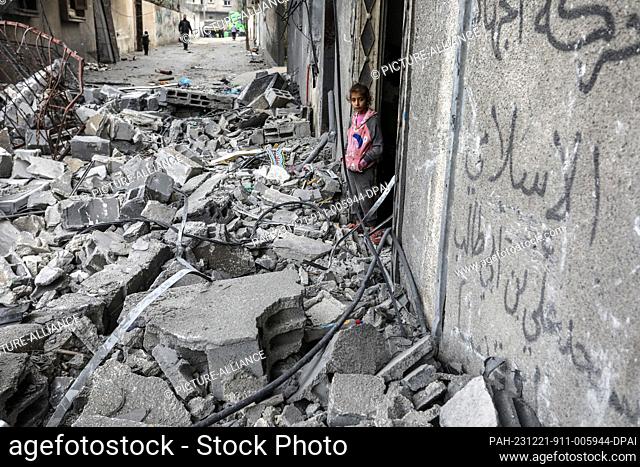 21 December 2023, Palestinian Territories, Rafah: A Palestinian girl stands among the rubble of destroyed buildings after an Israeli air strike in Rafah