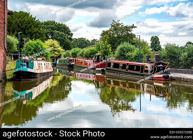 ELLESMERE, SHROPSHIRE, UK - JULY 12 : Narrow boats in Ellesmere, Shropshire on July 12, 2021. Three unidentified people