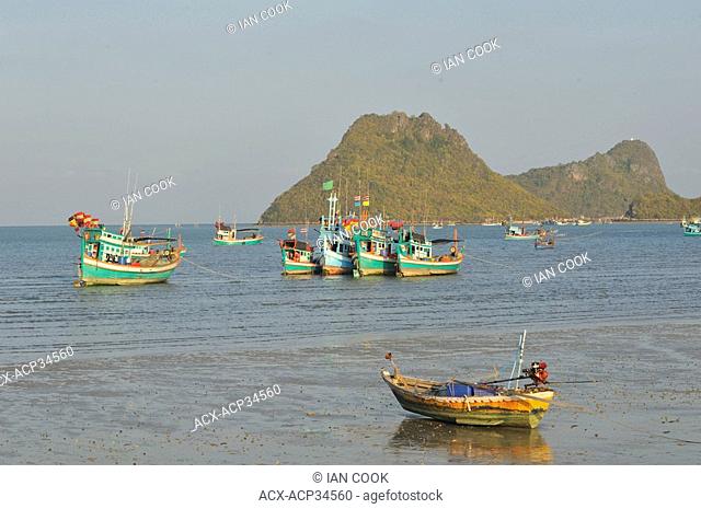 dinghy on beach and fishing boats at anchor, Prachuap Kiri Khan Harbour, Gulf of Thailand, Thailand