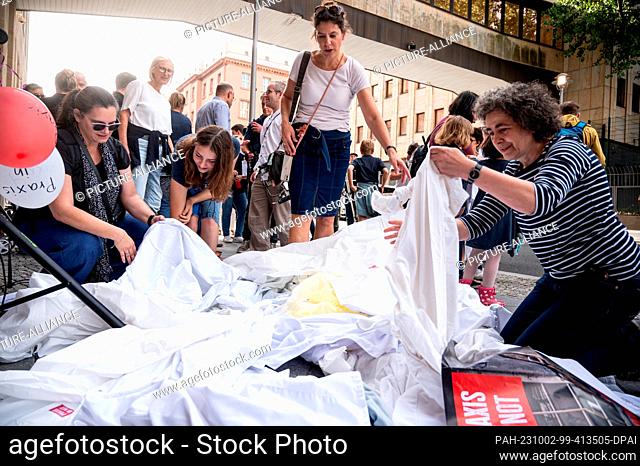 02 October 2023, Berlin: Doctors throw their scrubs in front of the Ministry of Health during the ""Doctors in Need"" protest march