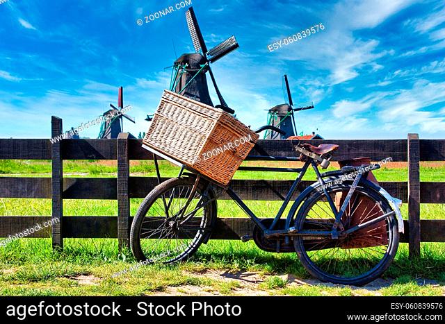 Bicycle with windmill and blue sky background. Scenic countryside landscape close to Amsterdam in Netherlands