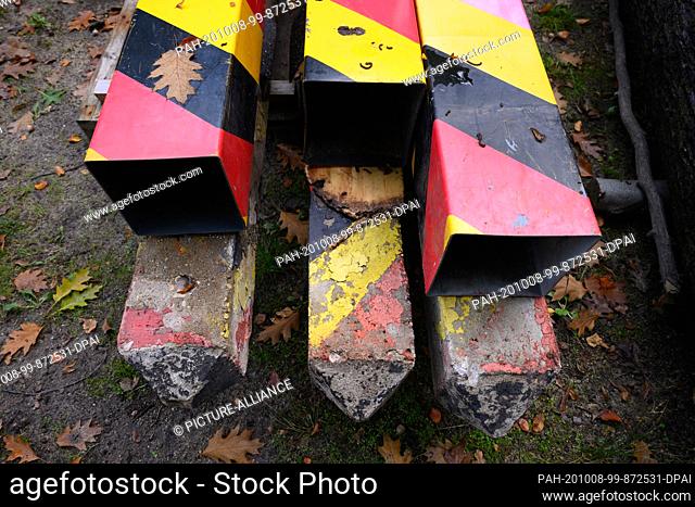 08 October 2020, Saxony, Bad Muskau: Old marking columns from GDR times and the black-red-gold plastic coating are located in the Fürst-Pückler-Park on the...