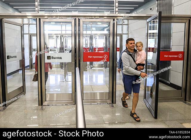 RUSSIA, MOSCOW - SEPTEMBER 6, 2023: A man carries a child as he leaves Pykhtino Station on the Solntsevskaya Line of the Moscow Metro