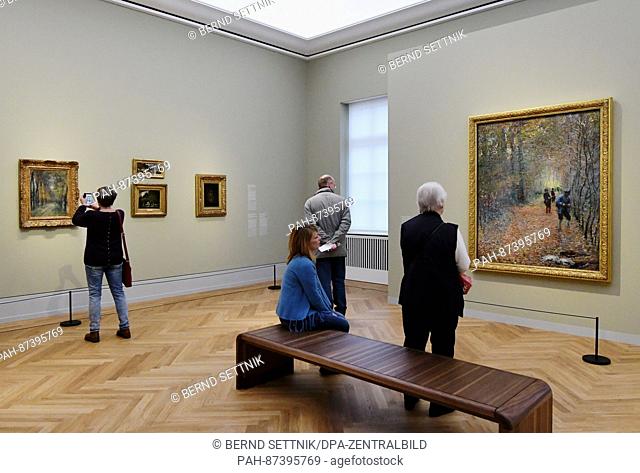 Visitors look at the painting 'The Hunt' (r) by Claude Monet at the Museum Barberini in Potsdam, Germany, 21 January 2017