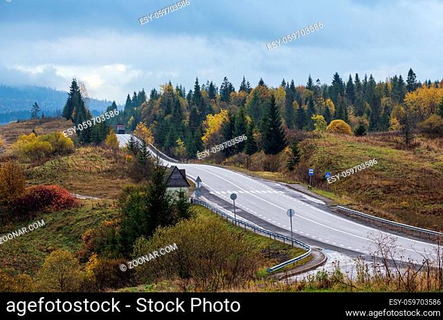 Hazy and overcast Carpathian Mountains and highway on mountain pass, Ukraine