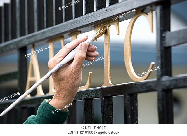 England, London, Wimbledon. The AELTC sign on a gate is painted before the Wimbledon Tennis Championships 2010