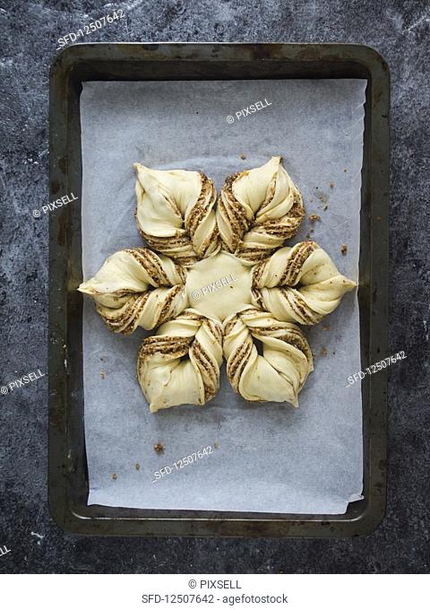Sweet Christmas bread in a star shape with cinnamon and almonds, unbaked
