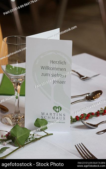 14 October 2023, Thuringia, Jena: A welcome card stands on a table at the 7th Martinsschmaus - a meal for socially needy people - at the Stadtkirche St