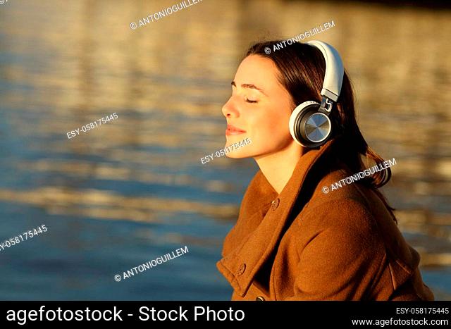 Woman meditating listening with headphones in winter