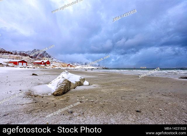 On the snow-covered beach of the Grotfjord in Northern Norway