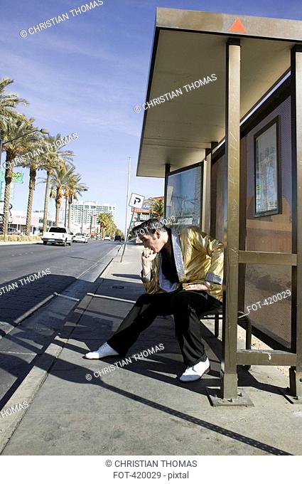 Elvis impersonator posing at a bus stop