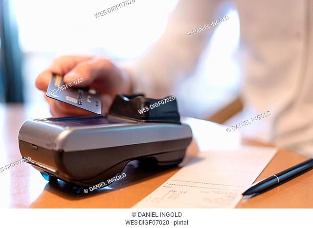 Man paying bill with credit card, close-up