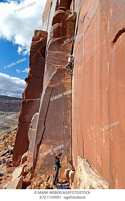 Man rock climbing a route called Amaretto Corner on Super Crack Buttress at Indian Creek Canyon in southern Utah