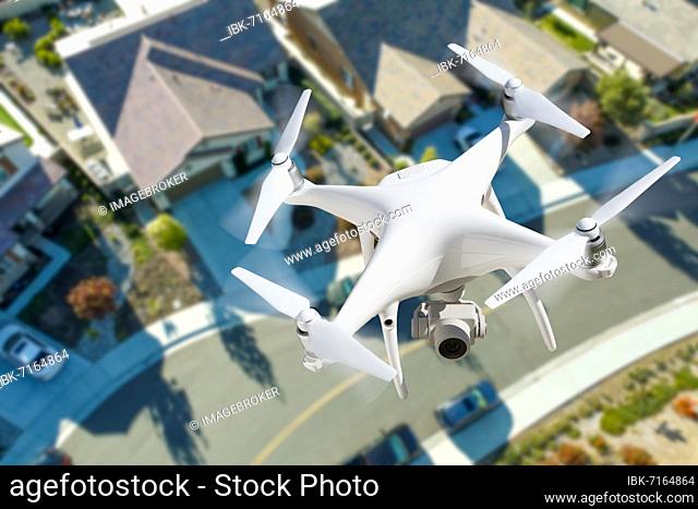 Unmanned aircraft system quadcopter drone in the air over residential neighborhood