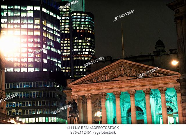 Contrast of modern and ancient buildings. The old Stock Exchange building iluminated at night. City of London, England, UK, Europe