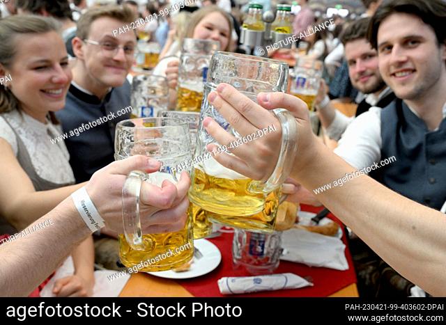 21 April 2023, Bavaria, Munich: Guests celebrate with beer in the Festhalle Bayernland at the start of the Spring Festival on the Theresienwiese