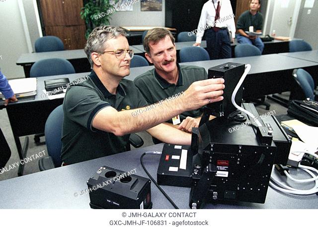 Astronauts Marc Garneau (left) and Joseph R. Tanner, STS-97 mission specialists, familiarize themselves with an IMAX 3D motion picture camera during a training...