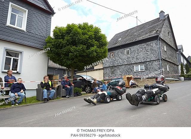 Participants in the Bobbycar-Rheinland-Pfalz-Meisterschaftn (Bobbycar Championships of Rhineland-Palatinate) roll down a hill in Niedert, Germany, 20 June 2015