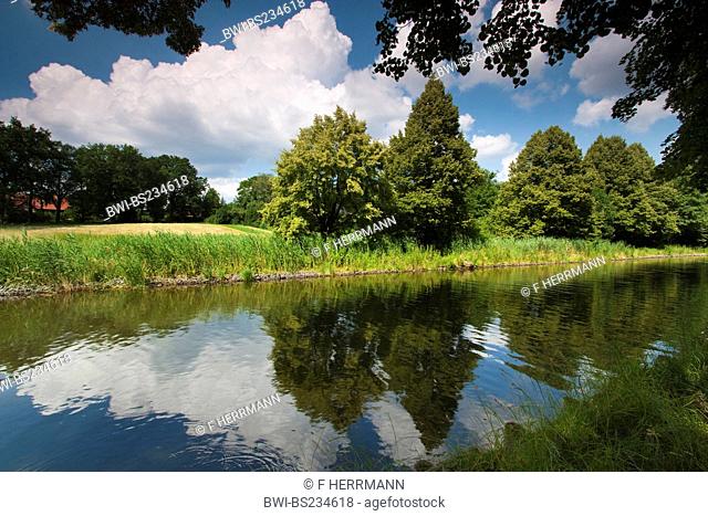 reflections of clouds and shore vegetation in the water of a canal, Germany, Brandenburg, Vogtlaendische Schweiz