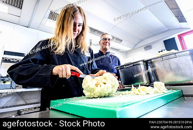 04 July 2023, Schleswig-Holstein, Kiel: 14-year-old student Ylvi Paschold (l) prepares cauliflower together with Thomas König, Head of Corporate Catering