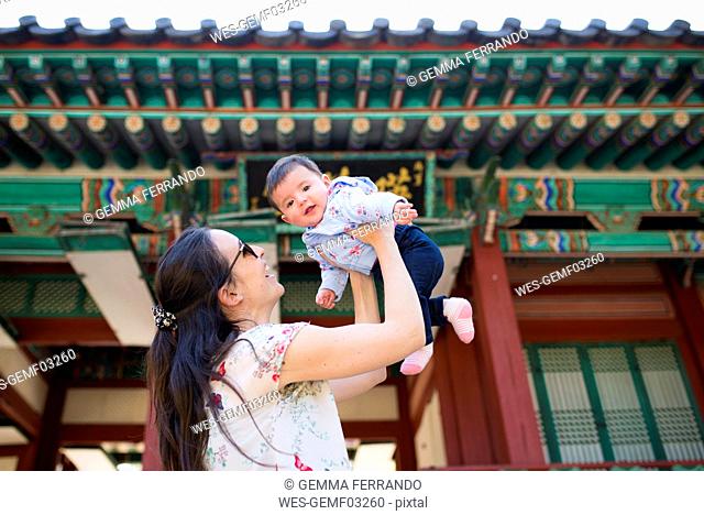 Mother and baby girl visiting pagoda in the Secret Garden, Changdeokgung, Seoul, South Korea