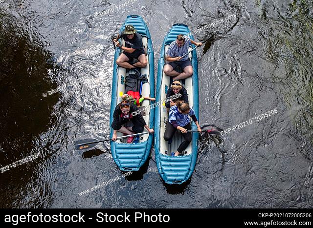 Water tourists enjoy summer weather in a boat on the Orlice river in Kostelec nad Orlici, Czech Republic, on July 20, 2021. (CTK Photo/David Tanecek)