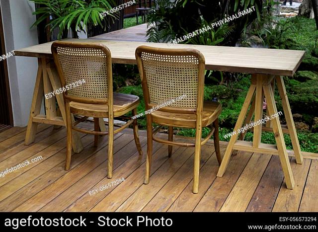 Wooden table and chairs in tropical garden, stock photo