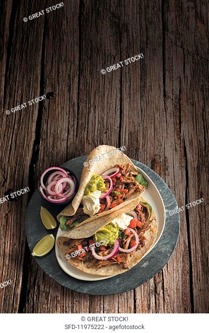 Tacos with beef brisket, salsa, red onions, sour cream and guacamole (Mexico)