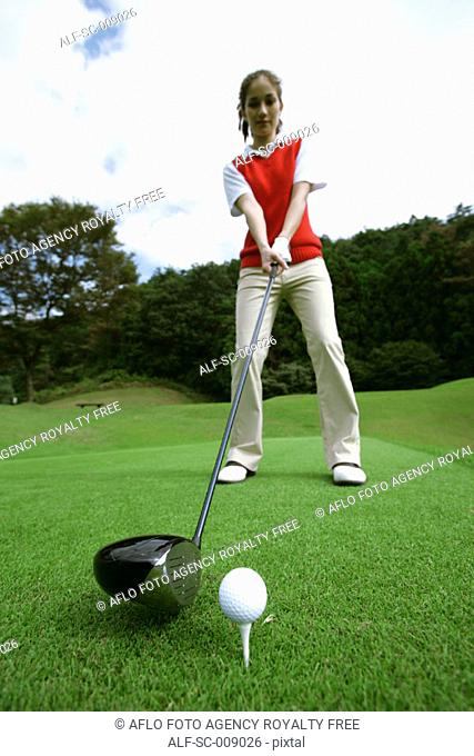 Female golfer preparing to hit her tee shot