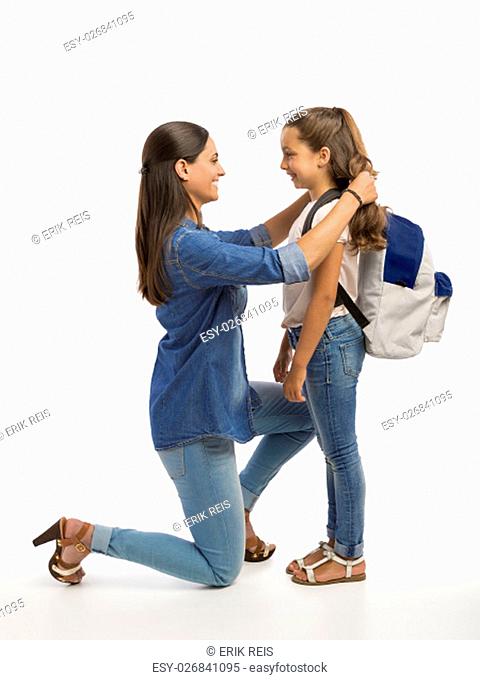 Mother hugging her little daughter and saying good-bye on the first day of school