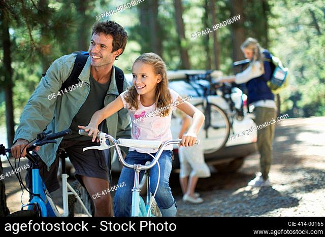 Father and daughter on bicycles in woods